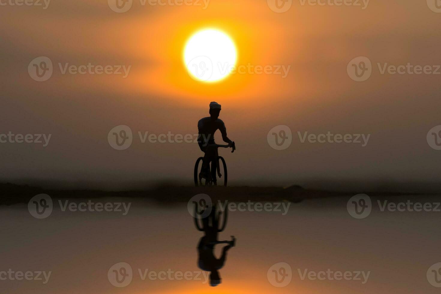 Silhouettes cycle on the beach at sunset. photo