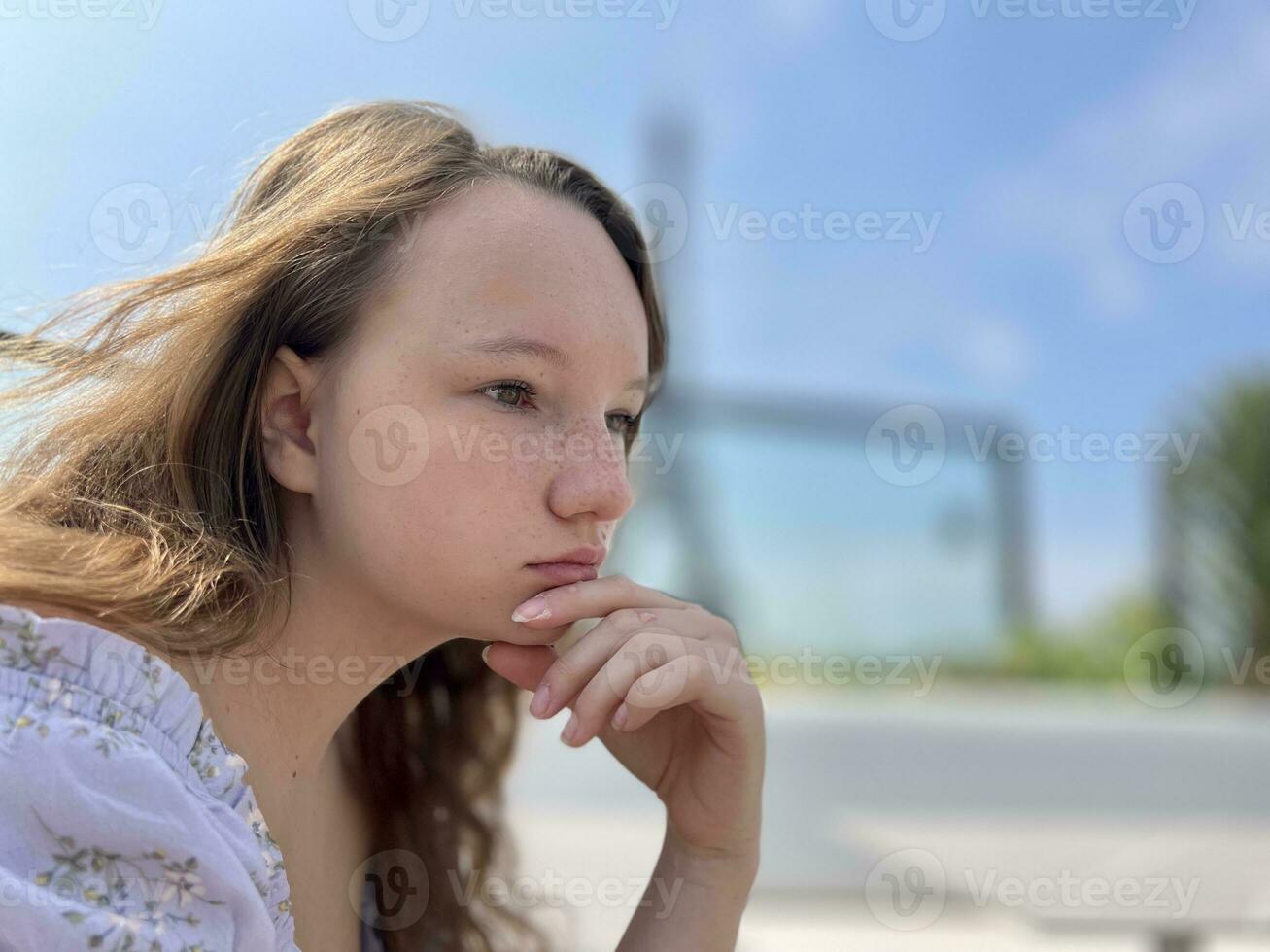 the face of a girl who sits against the backdrop of the Eiffel Tower she is thoughtfully relaxed beautiful there is a place for text for advertising photo