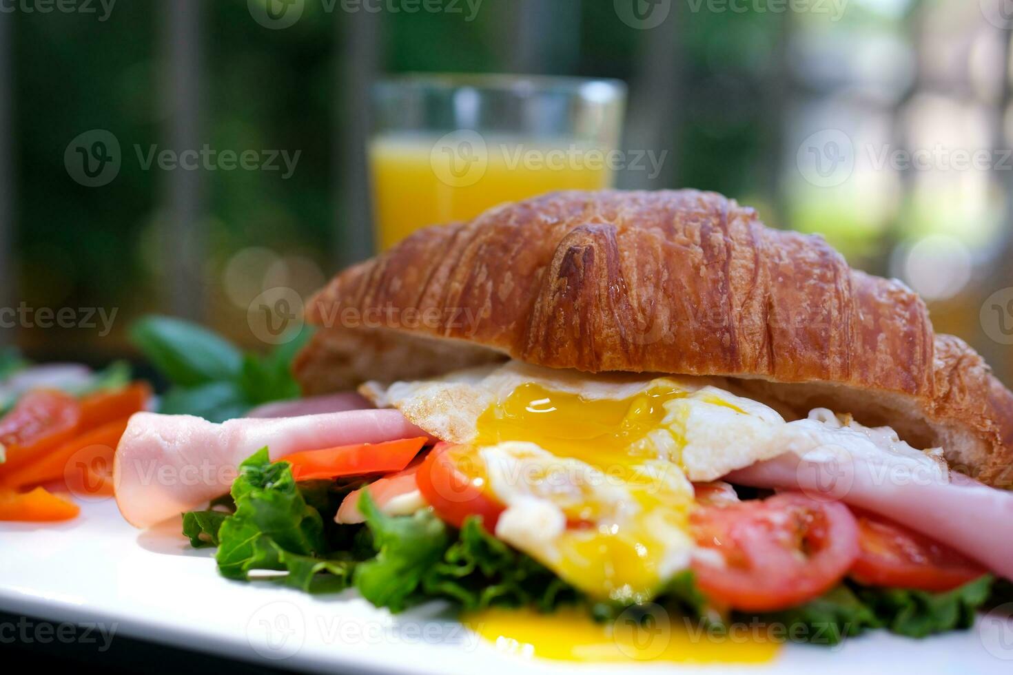 banner Croissant with prosciutto, poached egg, jamon blue, cheese, avocado, microgin and cherry tomatoes. Mediterranean appetizer. Breakfast concept. photo