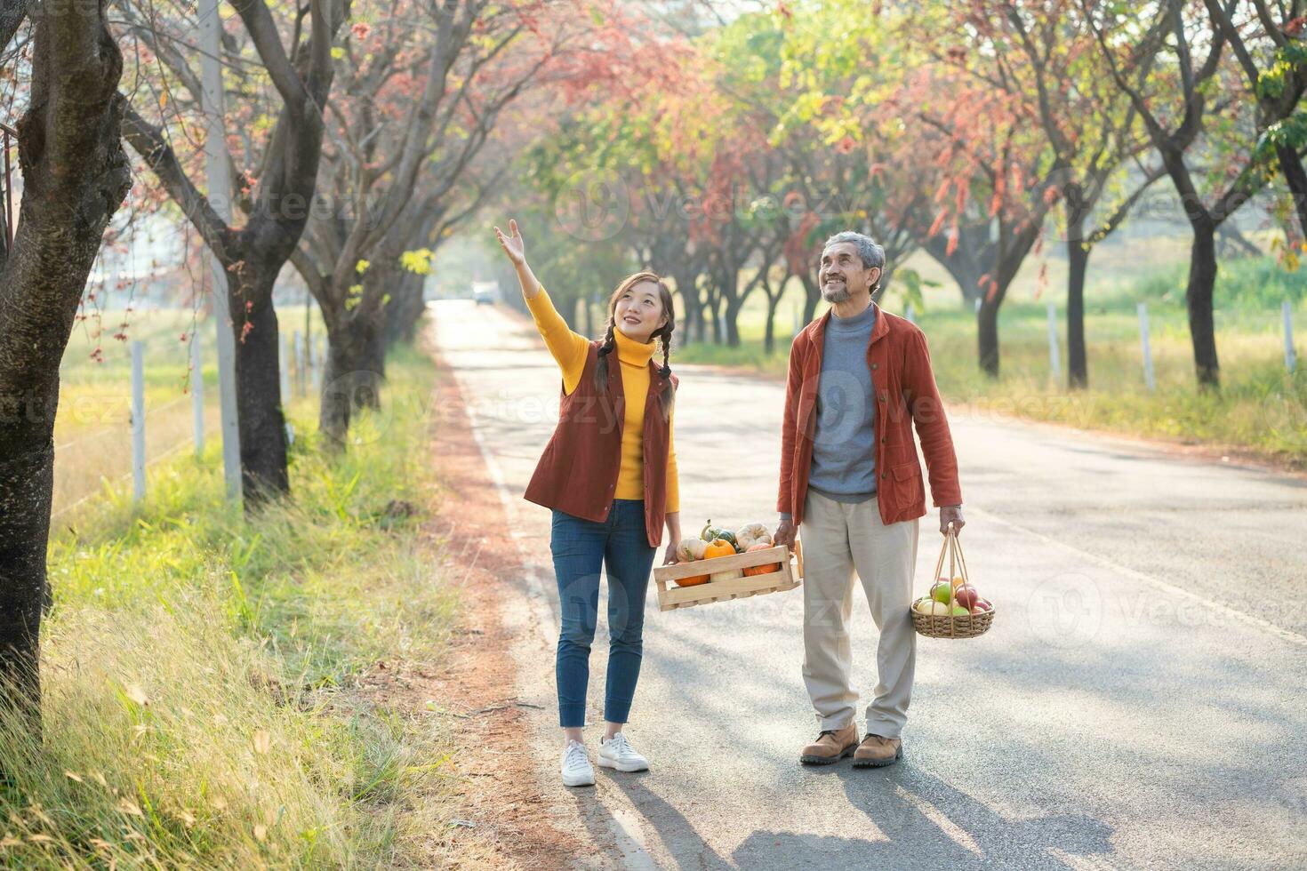 Beautiful woman with father pointing leaf fall on country road with maple  tree during autumn season 35591883 Stock Photo at Vecteezy