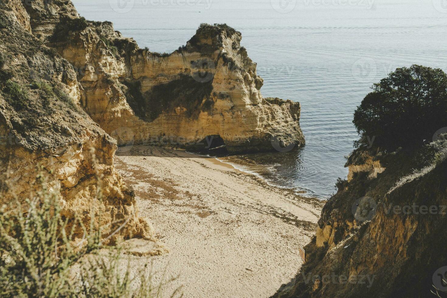 Empty and abandoned beach surrounded by cliffs on the coast of Algarve near Lagos. photo