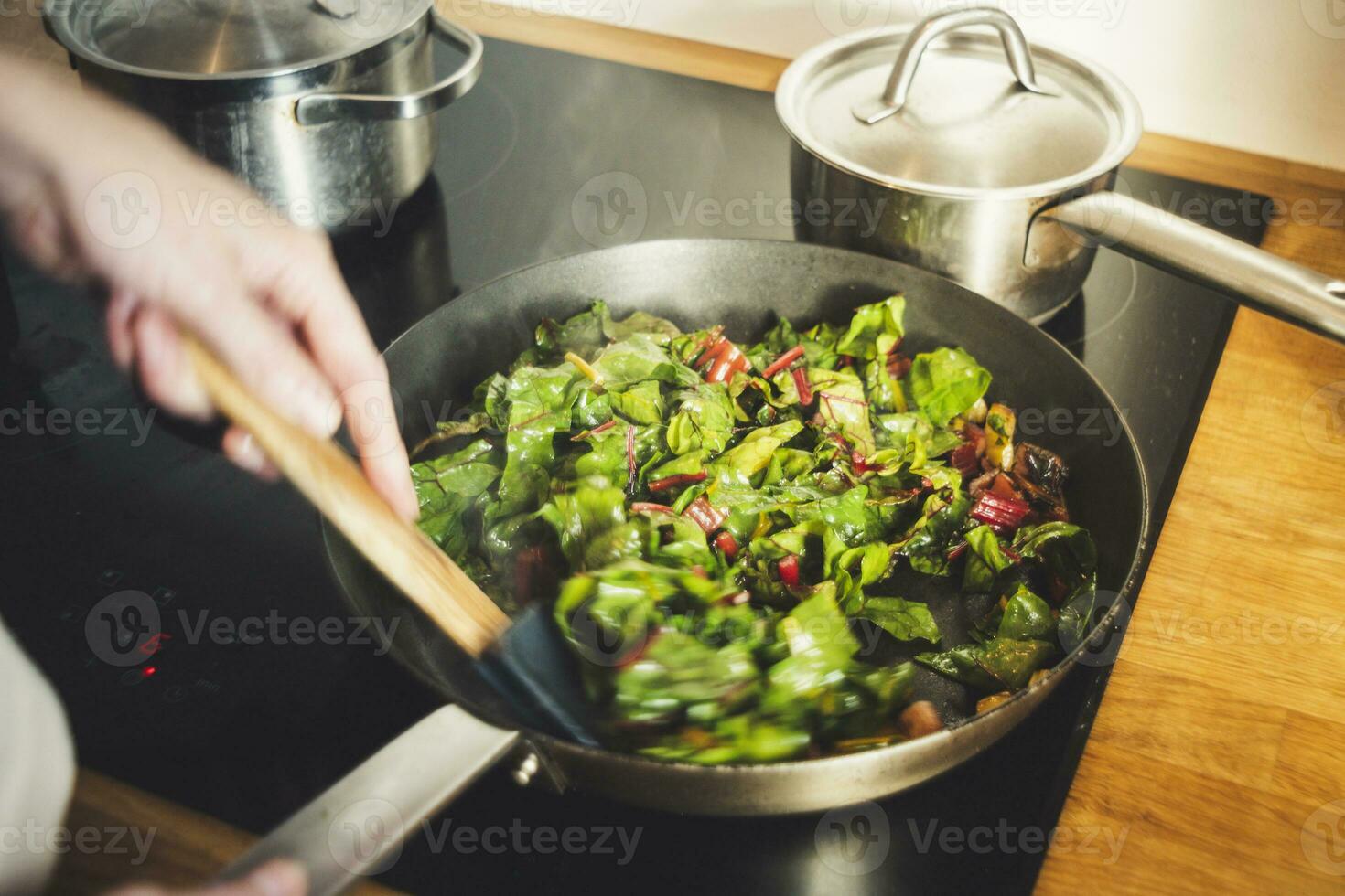 Preparing chard in a cooking pan with blurred motion photo