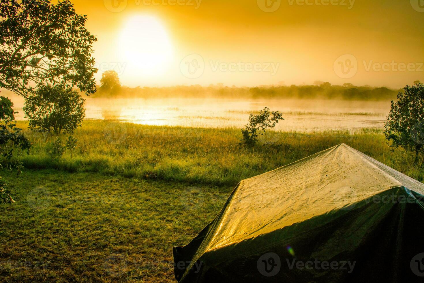 Shot of a tent at sunrise during caming at the lake in nature photo