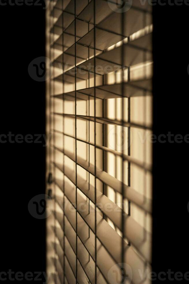 Vertical shot of venetian blinds creating a moody and noir inspired atmosphere. photo