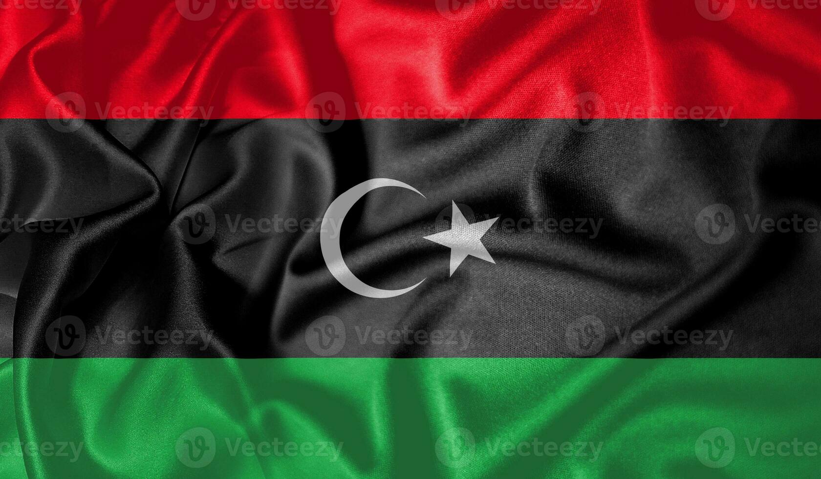 Libya flag waving fluttering in the wind with realistic texture fabric silk satin background photo