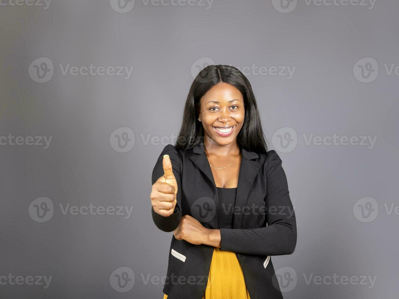 Beautiful young dark haired black woman in eloquent clothing with a happy expression how thump up for agreement sign with success business concept. photo