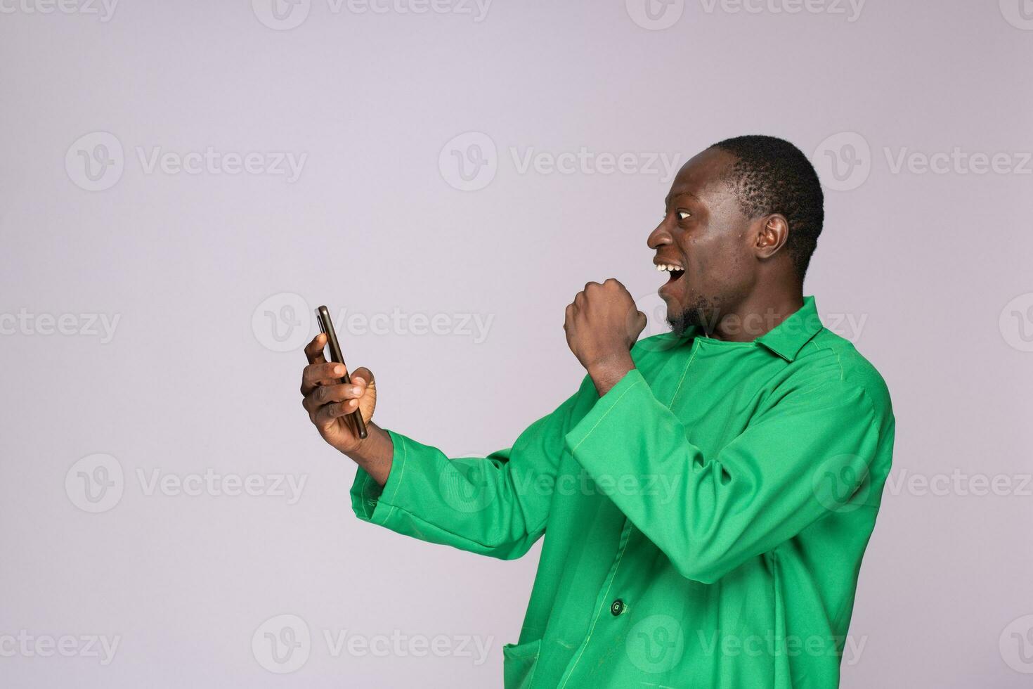 african farmer looking at his phone and rejoices like he won something photo