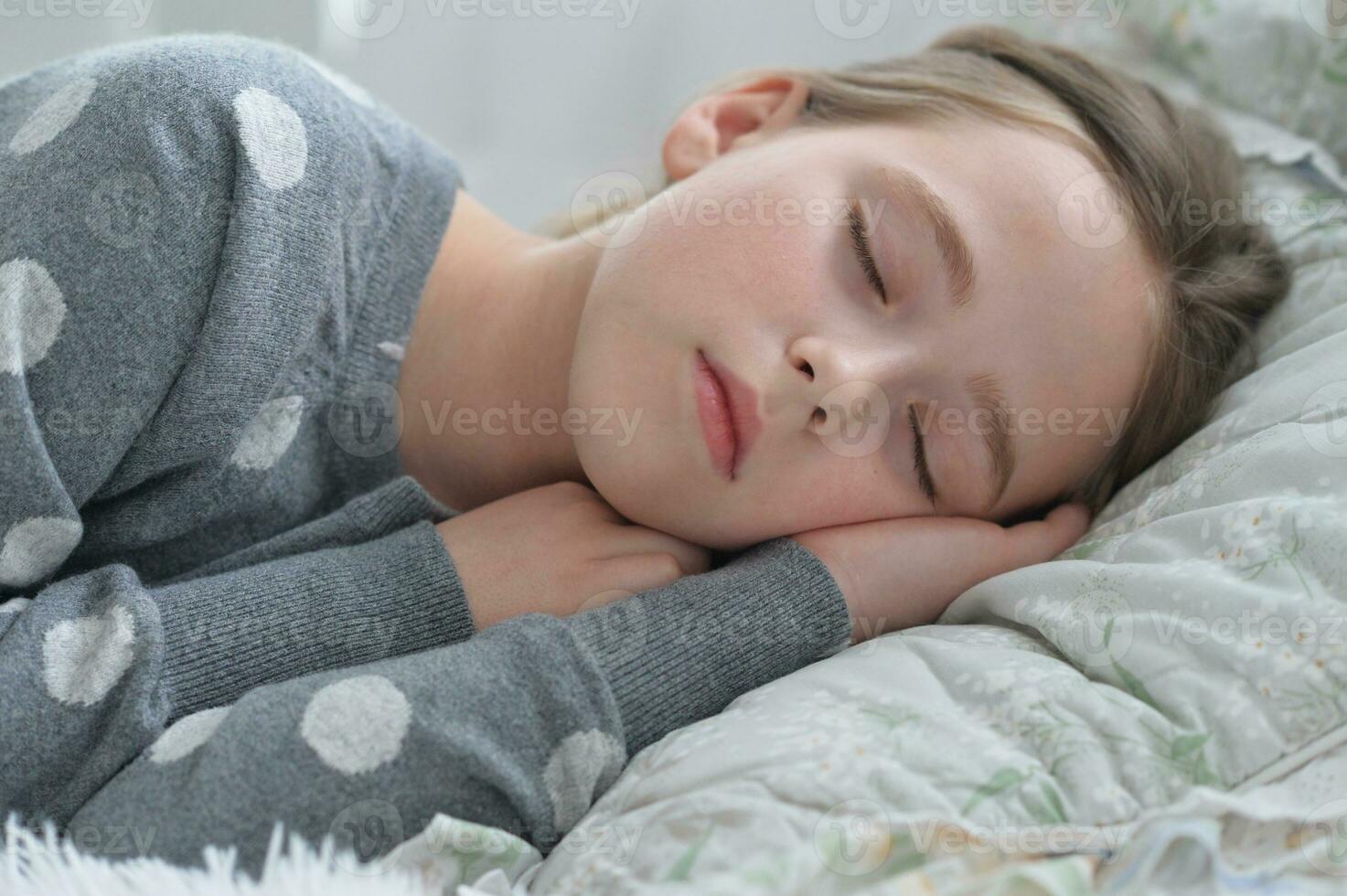 Sweet little girl sleeping in a bed photo