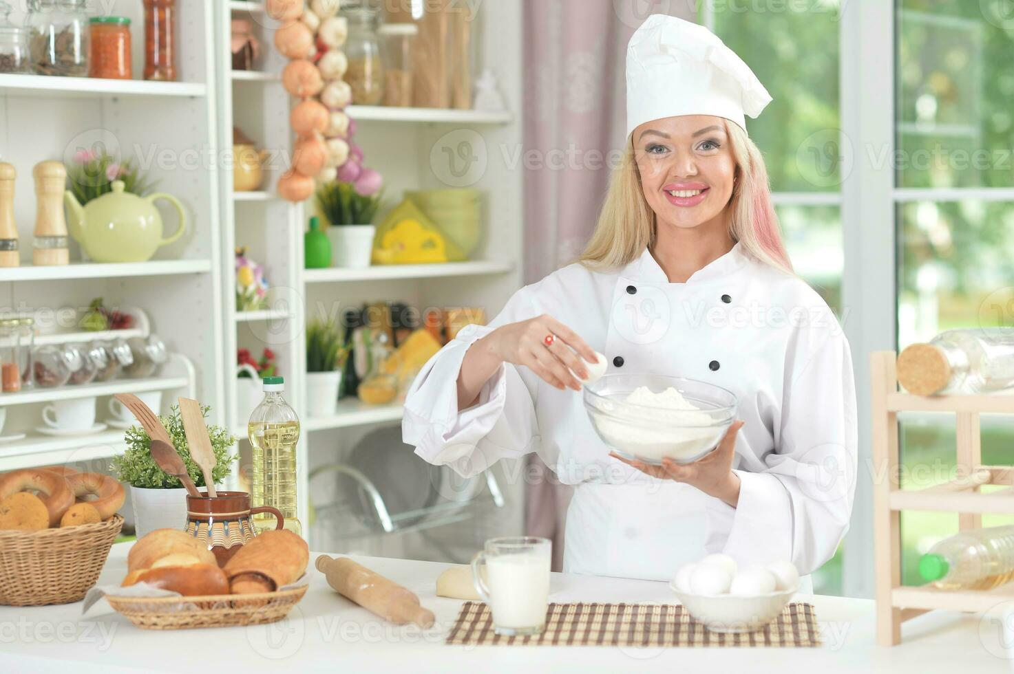 hermosa joven mujer en cocineros sombrero horneando a hogar foto
