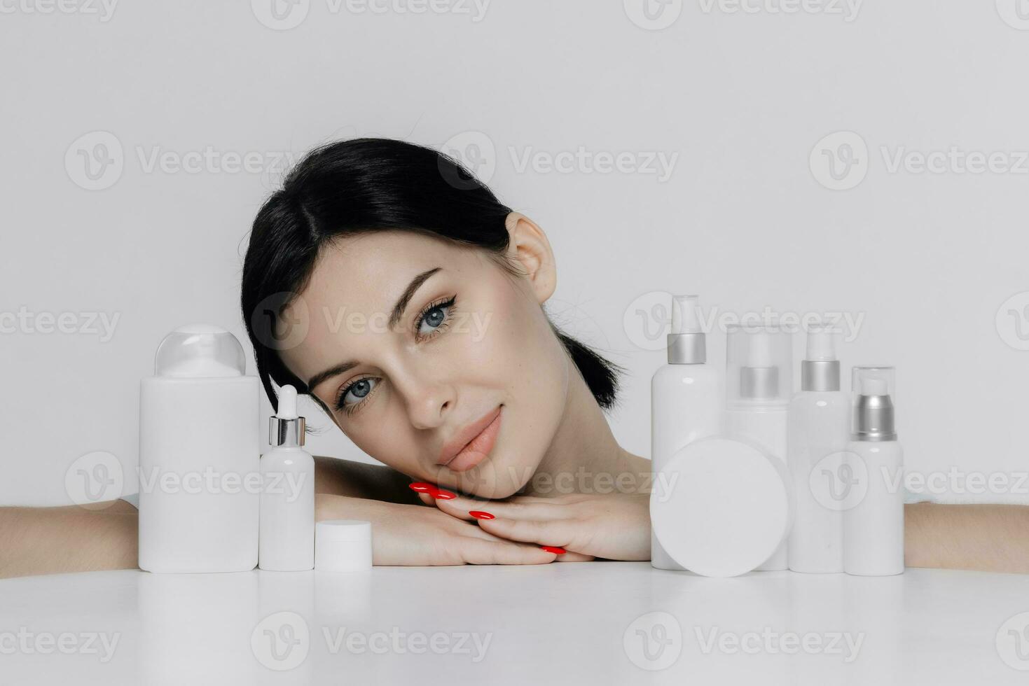 Woman showing cosmetic products branding mockup. Daily skincare and body care routine. Natural cosmetic cream, serum, white bottles packaging, bio organic product. photo