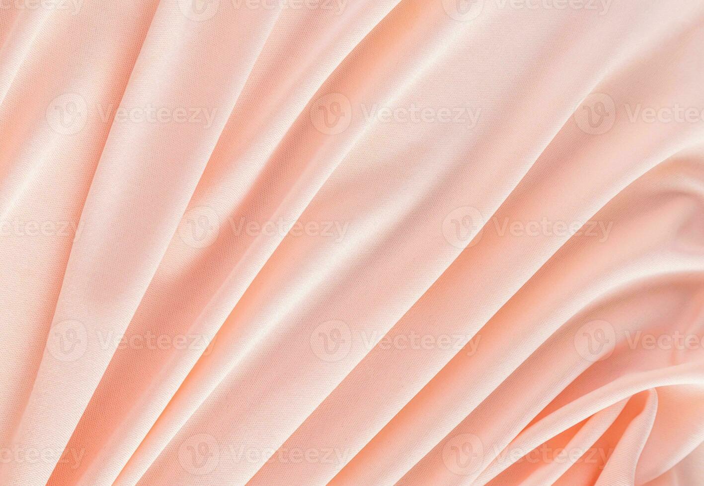 Elegant textile background in peach color with soft pleats. Festive background of the color of the year 2024 peach fuzz. A copy space. photo