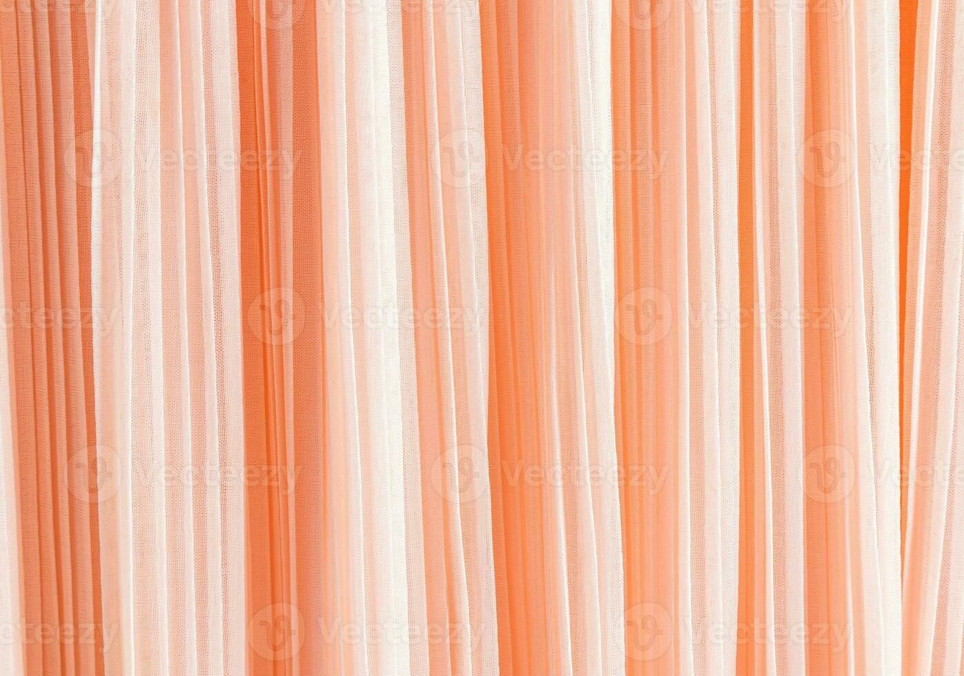 Delicate pleated pleats of silk fabric. Abstract background for design. Festive textiles. The trend of the color of the year 2024 is peach fuzz. photo
