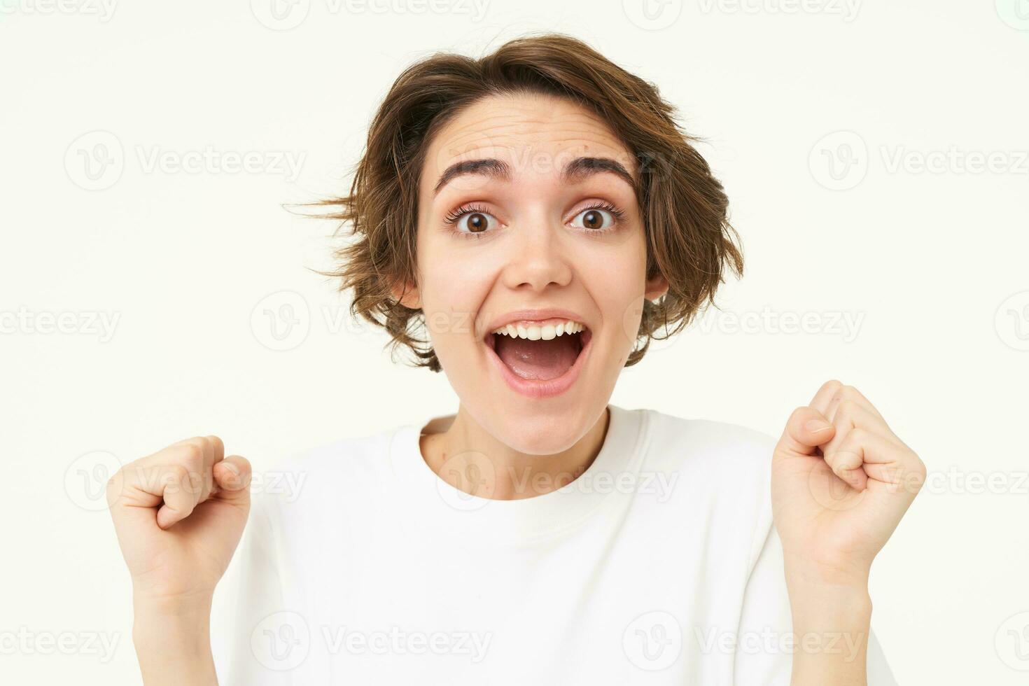 Close up portrait of excited woman, gasping and smiling, looking surprised, amazed by great news, isolated over white background photo