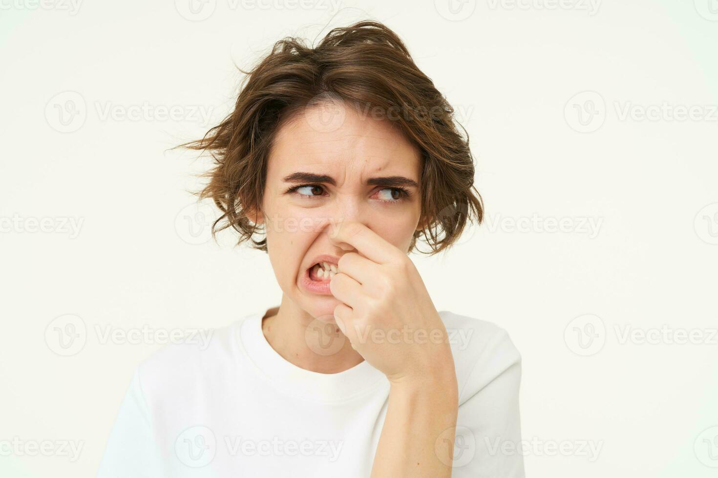 Woman shows dislike, shuts her nose from reeking bad smell, something