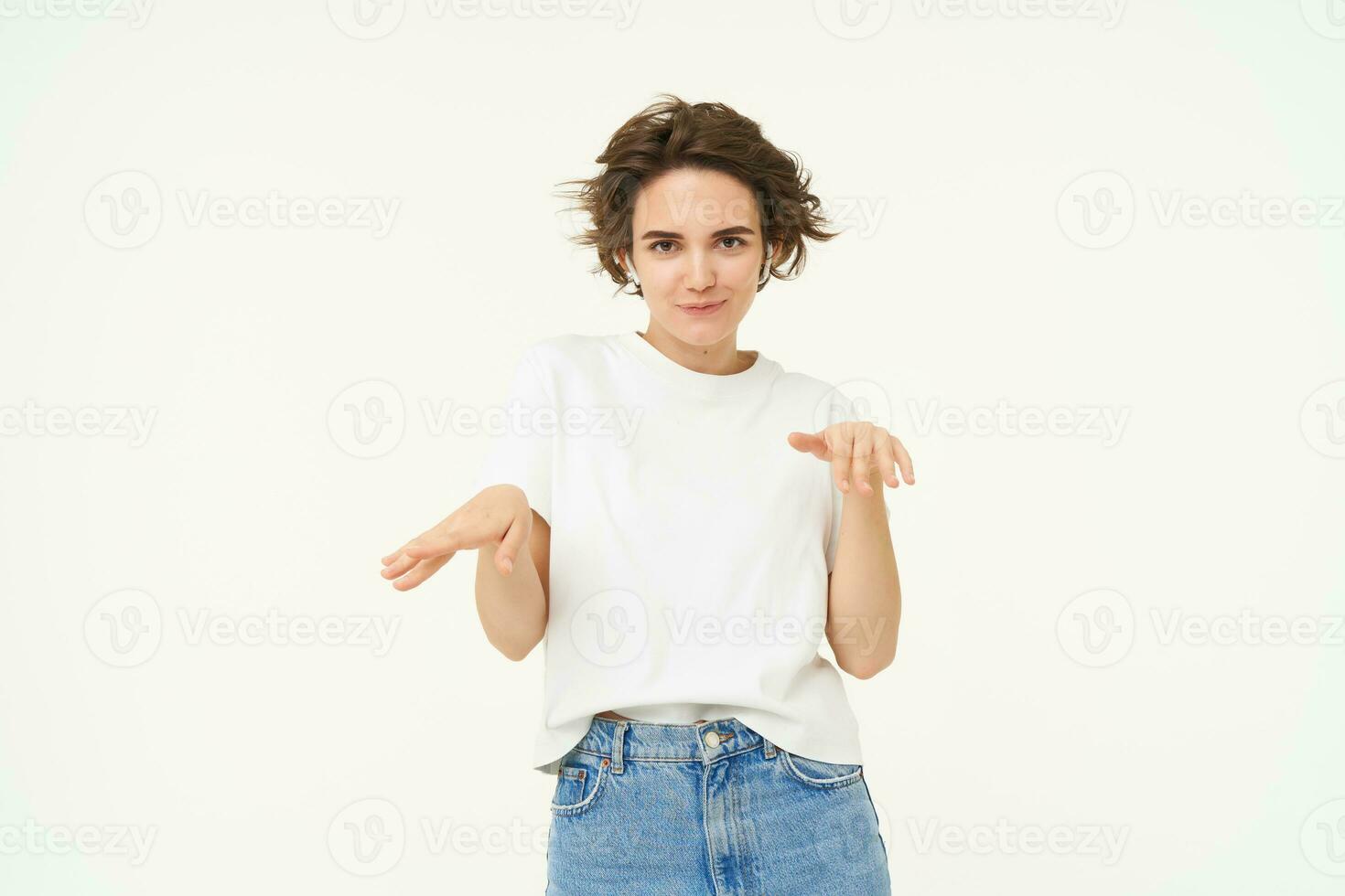 Portrait of happy young woman dancing, having fun, enjoying the music, posing over white studio background photo