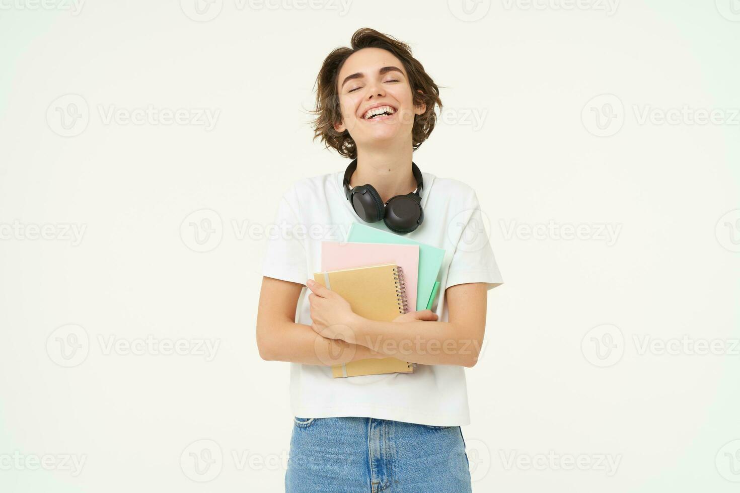 Image of stylish, modern girl student, holding workbook, documents. Woman teacher with papers standing over white background photo