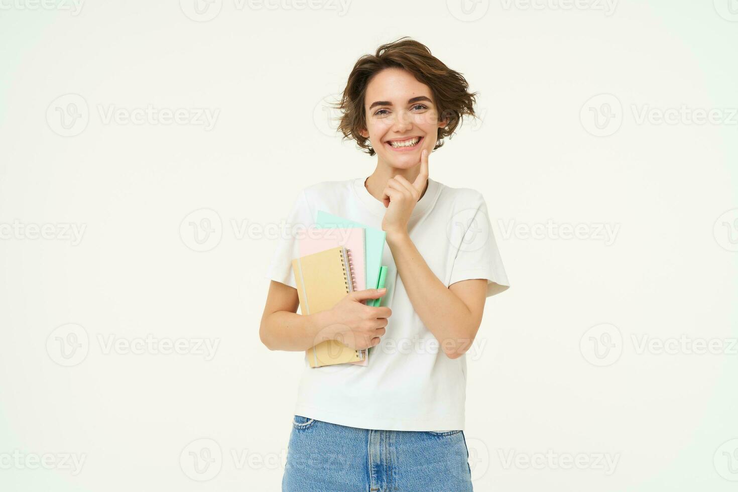 Image of stylish, modern girl student, holding workbook, documents. Woman teacher with papers standing over white background photo