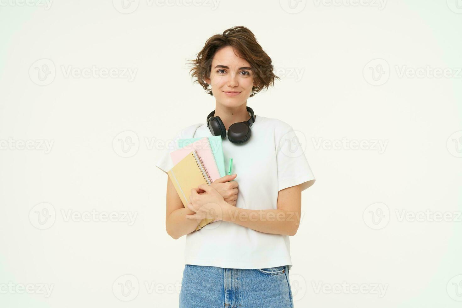 imagen de morena mujer en auriculares, en pie con documentos. estudiante con notas y libros de trabajo posando en contra blanco antecedentes foto