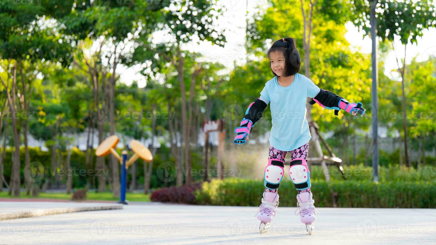 Asian kid girl practicing roller skating. Children wear elbow guard and knee guard to prevent severe injuries caused by impacts when playing challenging sports. Child 6 years old. photo