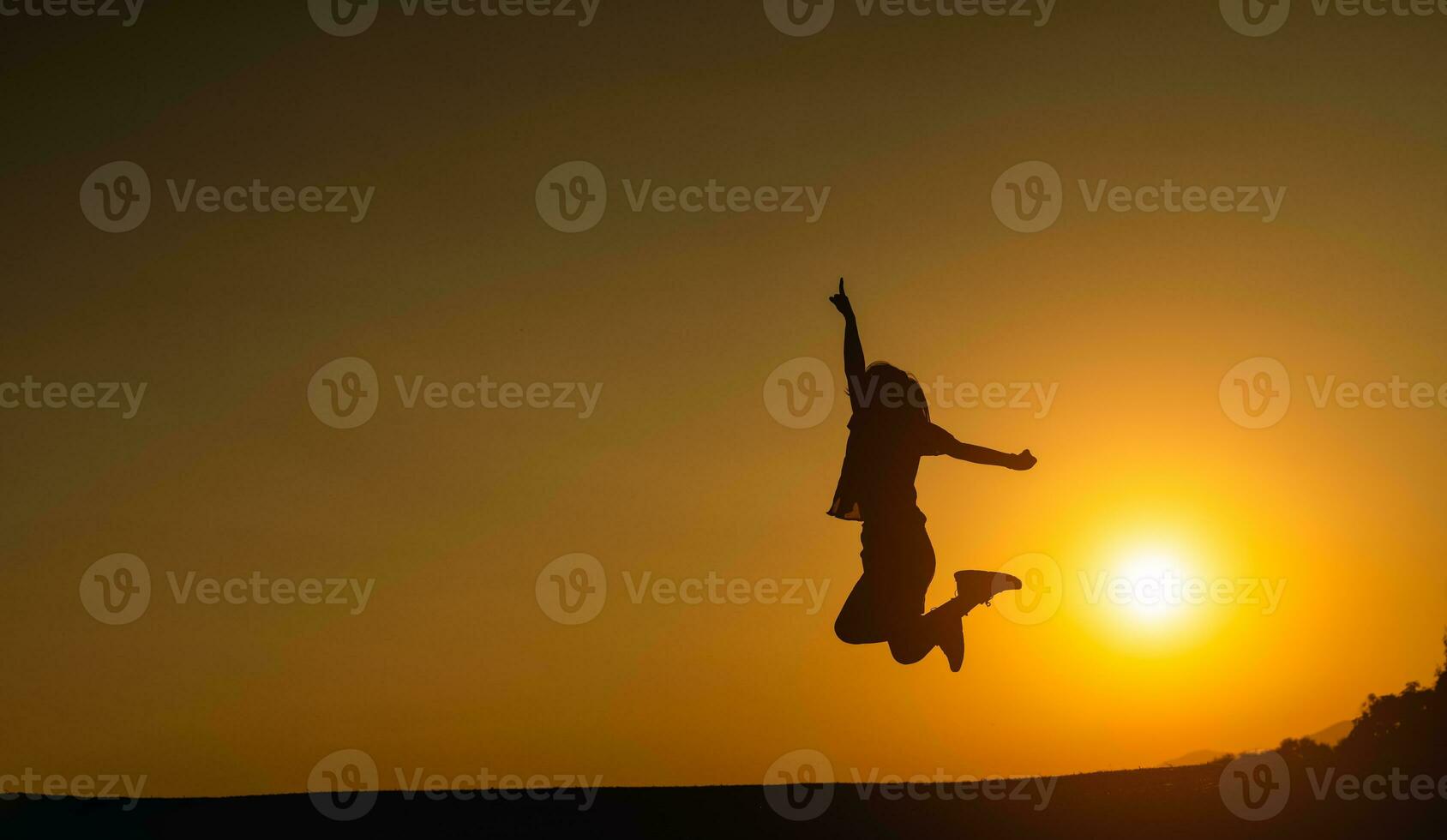 Silhouette of woman jumping and success for goal target on the field lawn with beautiful sunset sun light background for web banner and advertisement. photo