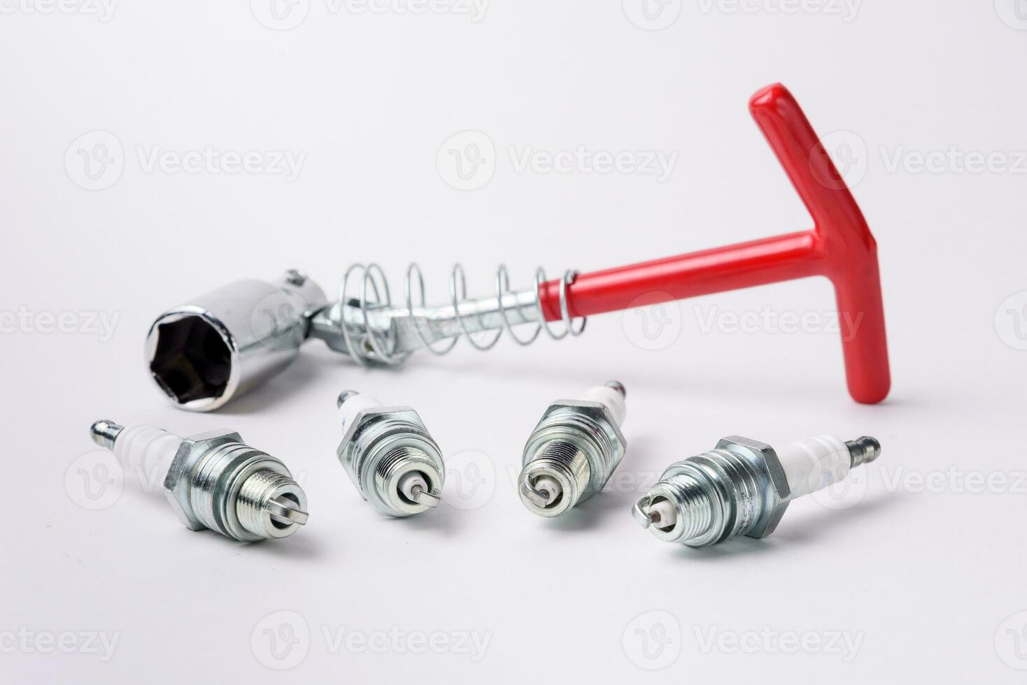 Car spark plugs and key on white background. Car spare parts. photo