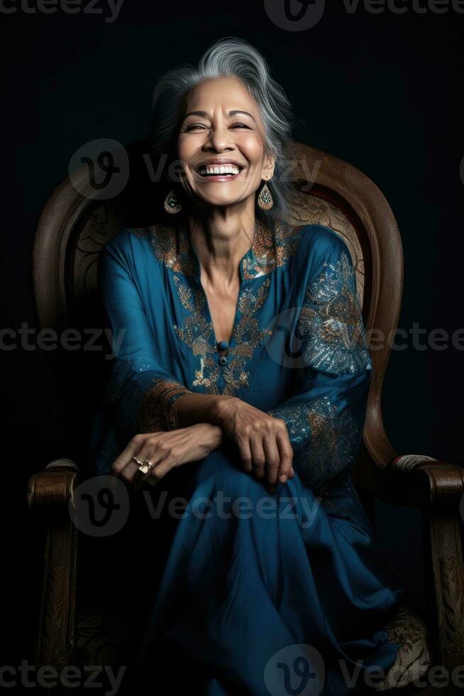 AI generated Elderly woman in a blue dress, sitting on a chair and smiling brightly photo