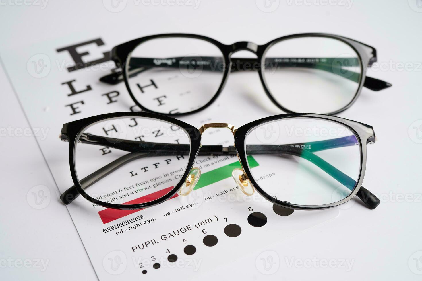 Glasses on eye exam chart to test eyesight accuracy of reading. photo