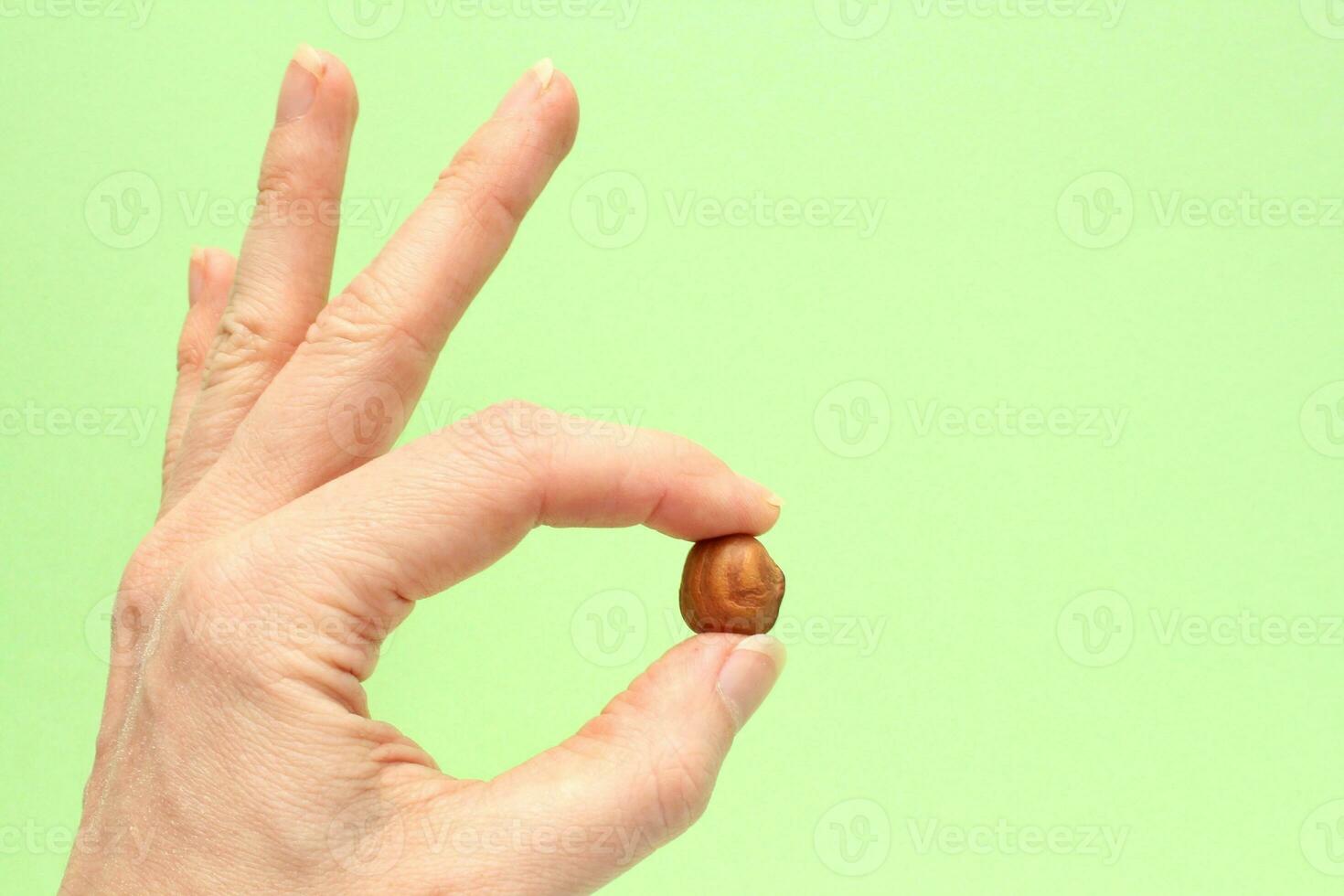 Woman holding organic hazelnut nut in hands. Nutrition healthy food choice concept. Calories dieting snack. Sustainable lifestyle. Close-up photo