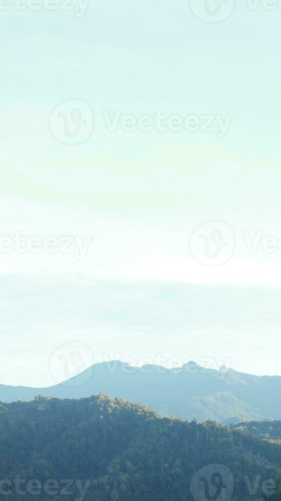 Beautiful sunrise over the mountain range at Gorontalo, Indonesia.  fluffy clouds on a bright blue sky. nature freshness concept photo