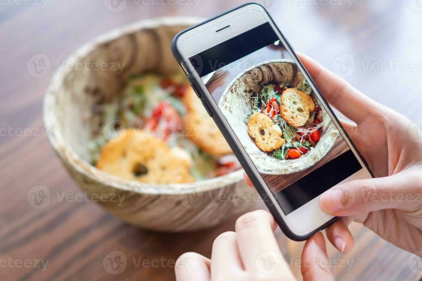 restaurant owner takes a picture of the food on the table with a smartphone to post on a website. Online food delivery, ordering service, influencer, review, social media, share, marketing, interes photo
