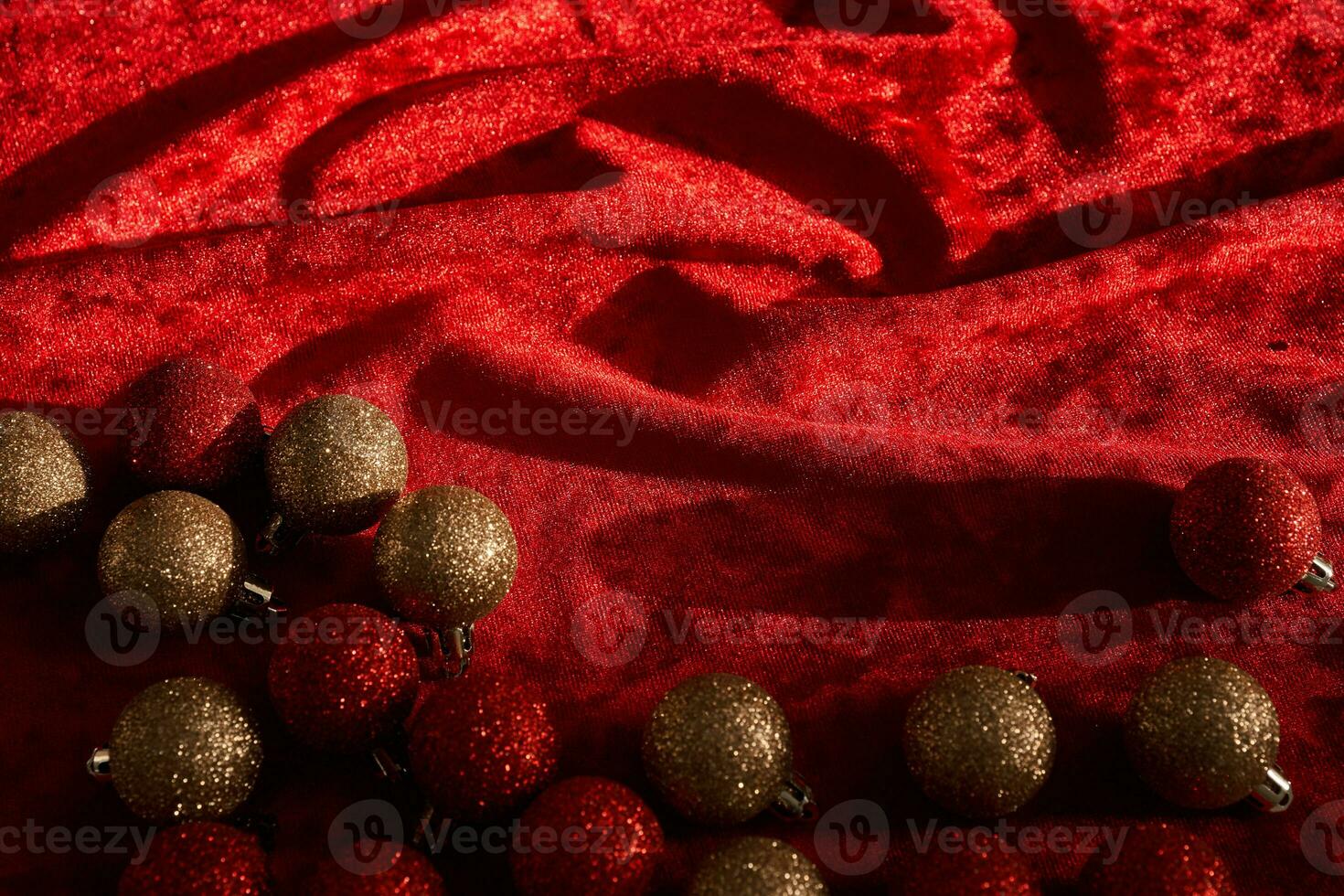 Abstract Christmas background made of red velvet fabric with Christmas balls. photo