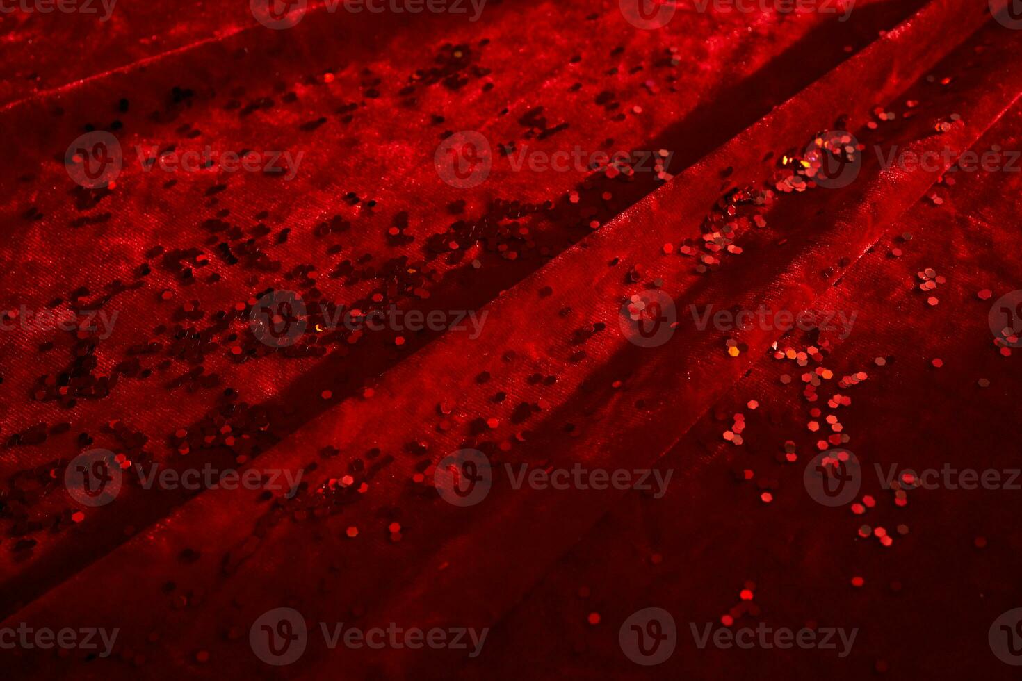 Abstract Christmas background made of red velvet fabric with red sparkles. photo