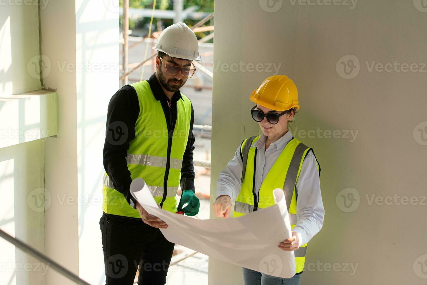 Engineer and architect working on the construction site, double-checking plans and process. photo