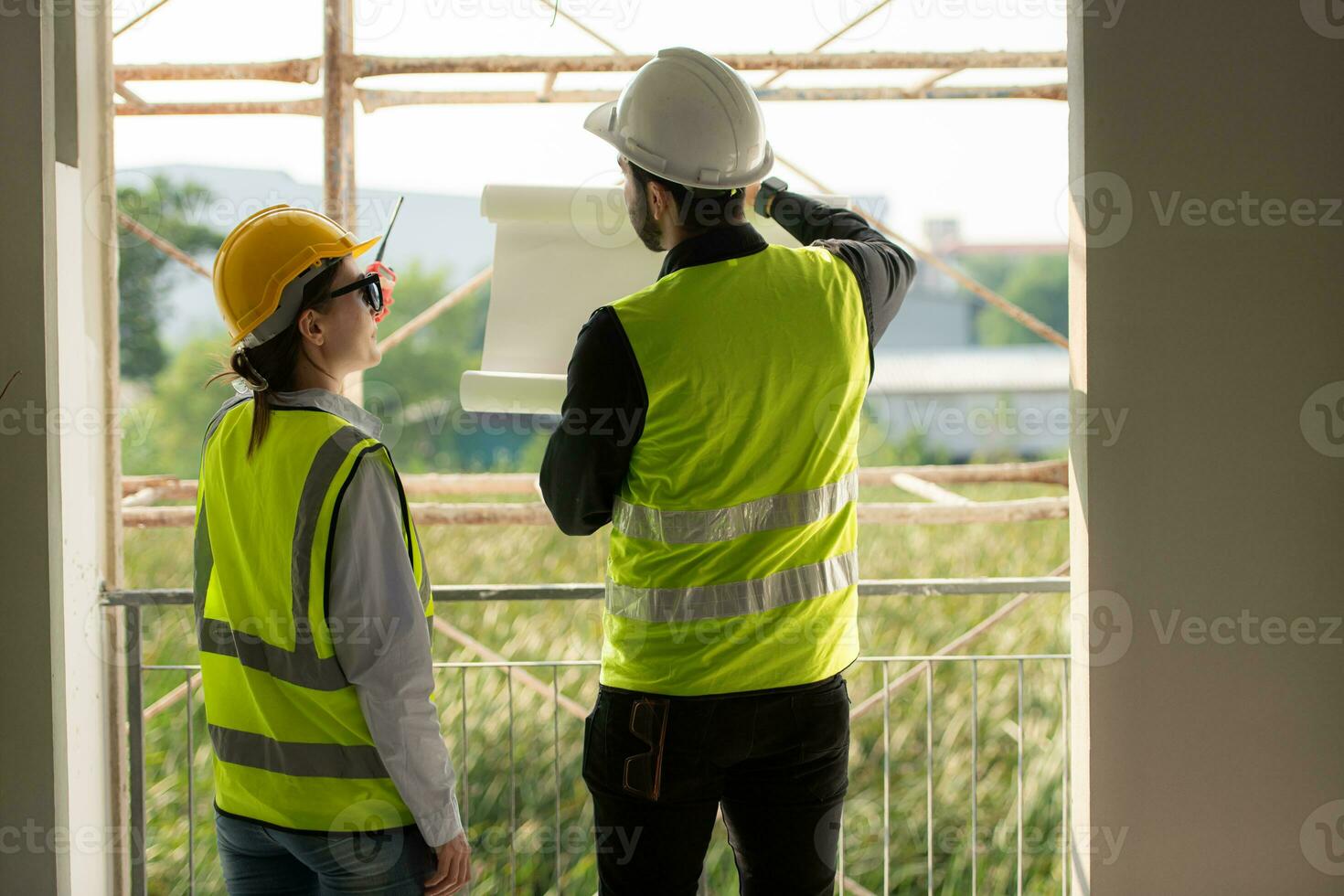 Engineer and architect working on the construction site, double-checking plans and process. photo
