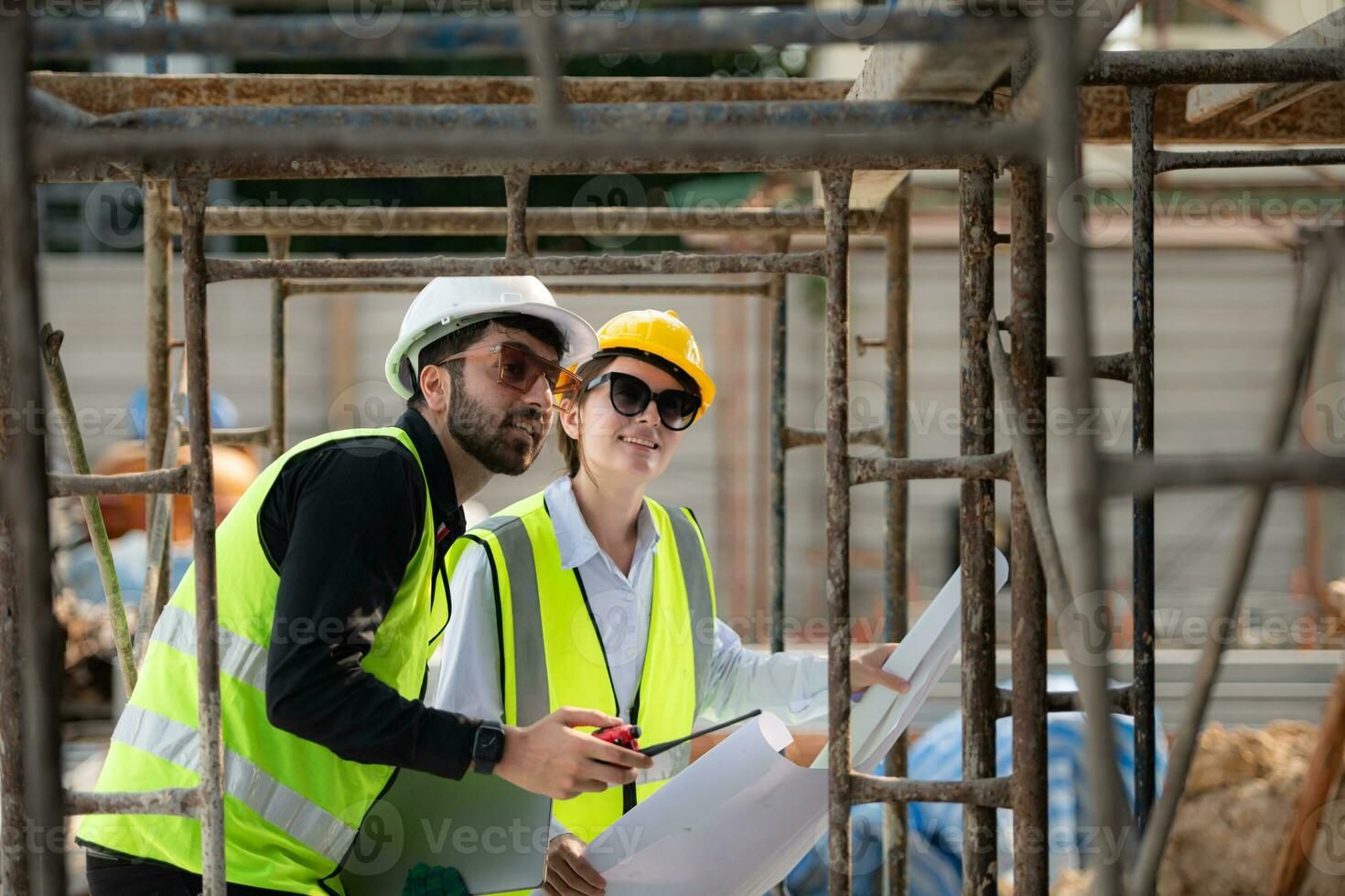 Engineer and architect working on the construction site, double-checking plans and process. photo