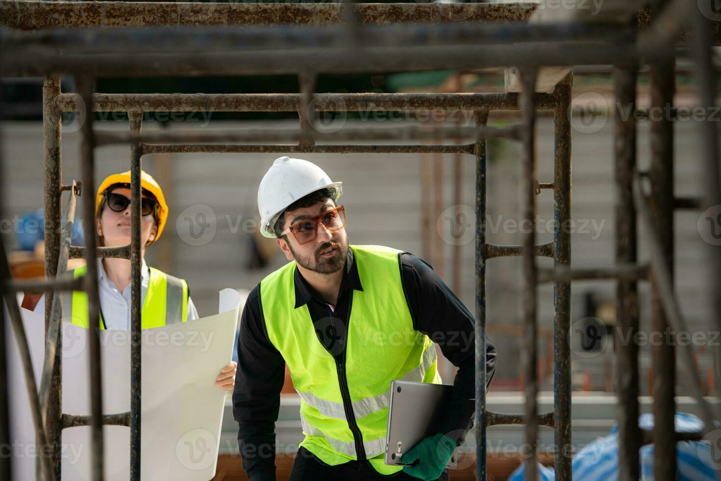 Engineer and architect working on the construction site, double-checking plans and process. photo