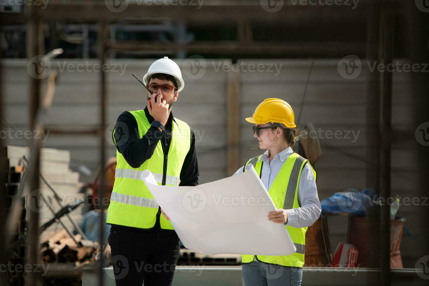 Engineer and architect working on the construction site, double-checking plans and process. photo