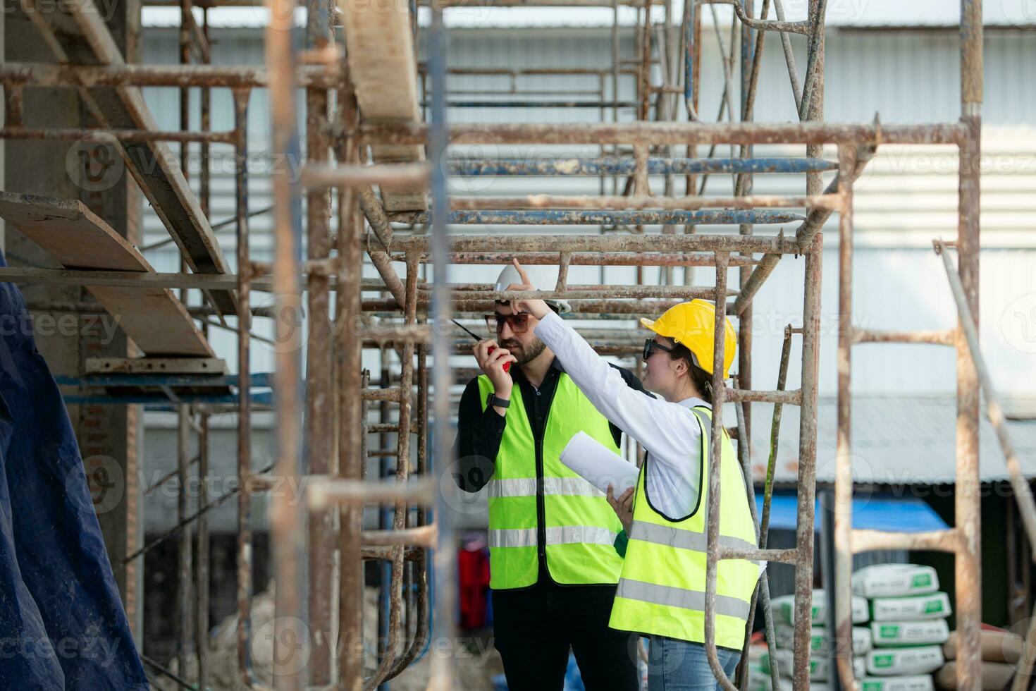 Engineer and architect working on the construction site, double-checking plans and process. photo