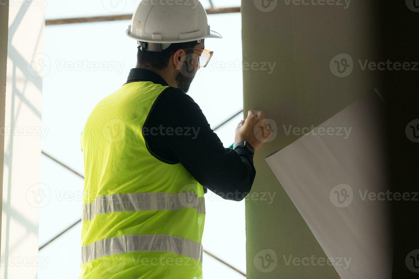 Engineer or architect working on the construction site, double-checking plans and process. photo