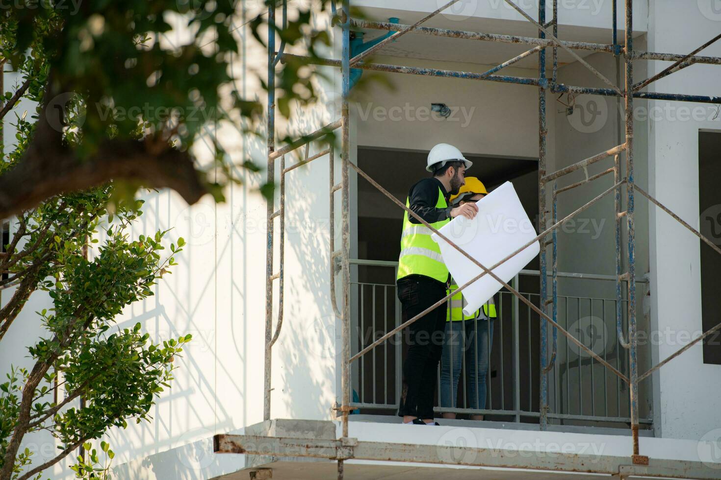 Engineer and architect working on the construction site, double-checking plans and process. photo