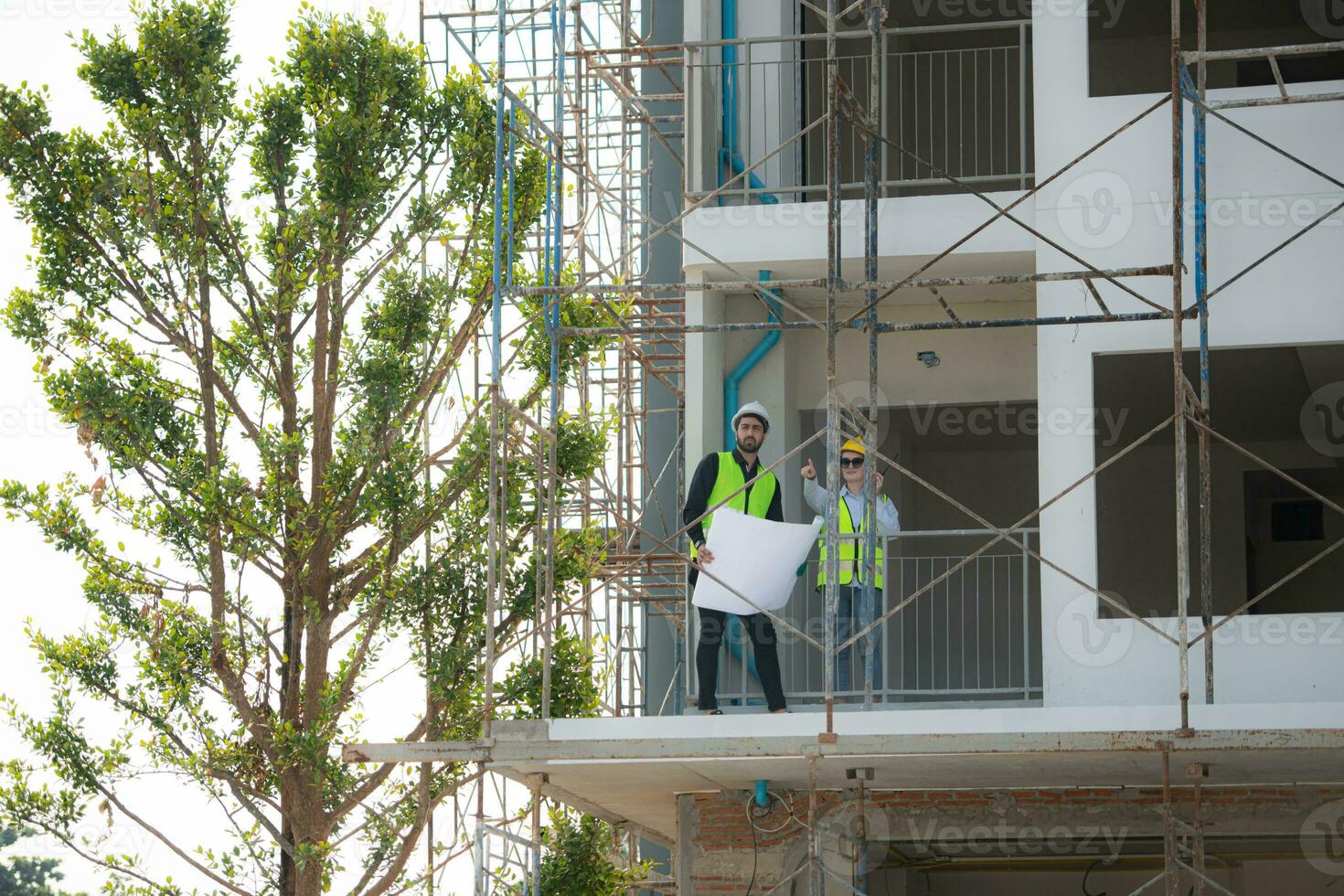 Engineer and architect working on the construction site, double-checking plans and process. photo