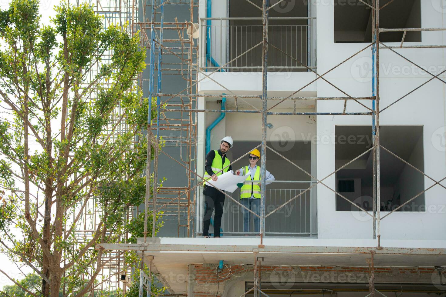 Engineer and architect working on the construction site, double-checking plans and process. photo