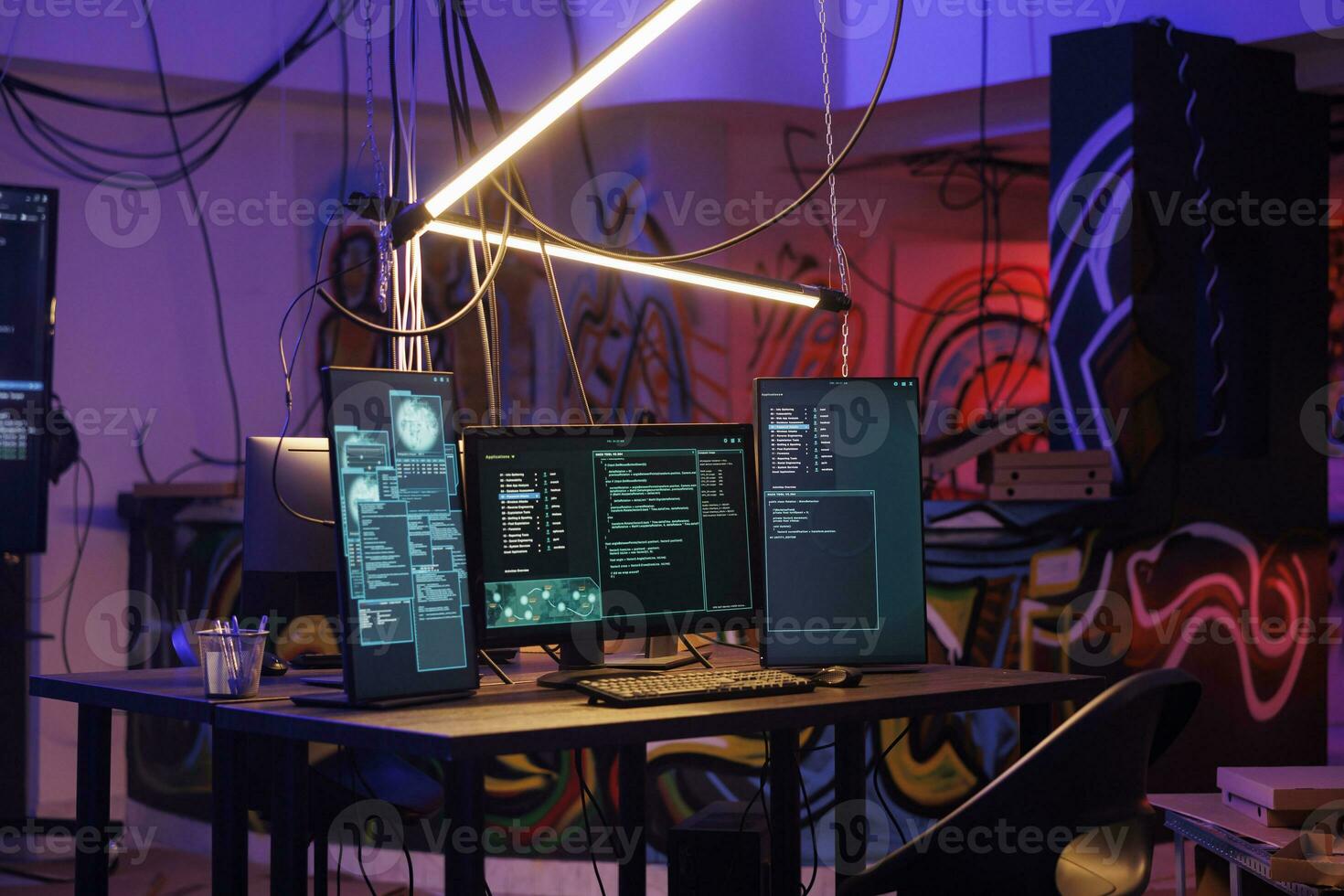 Computers with malicious ransomware running code on screens in abandoned warehouse. Encryption software multiple windows and password hacking activity on monitors in dark room photo