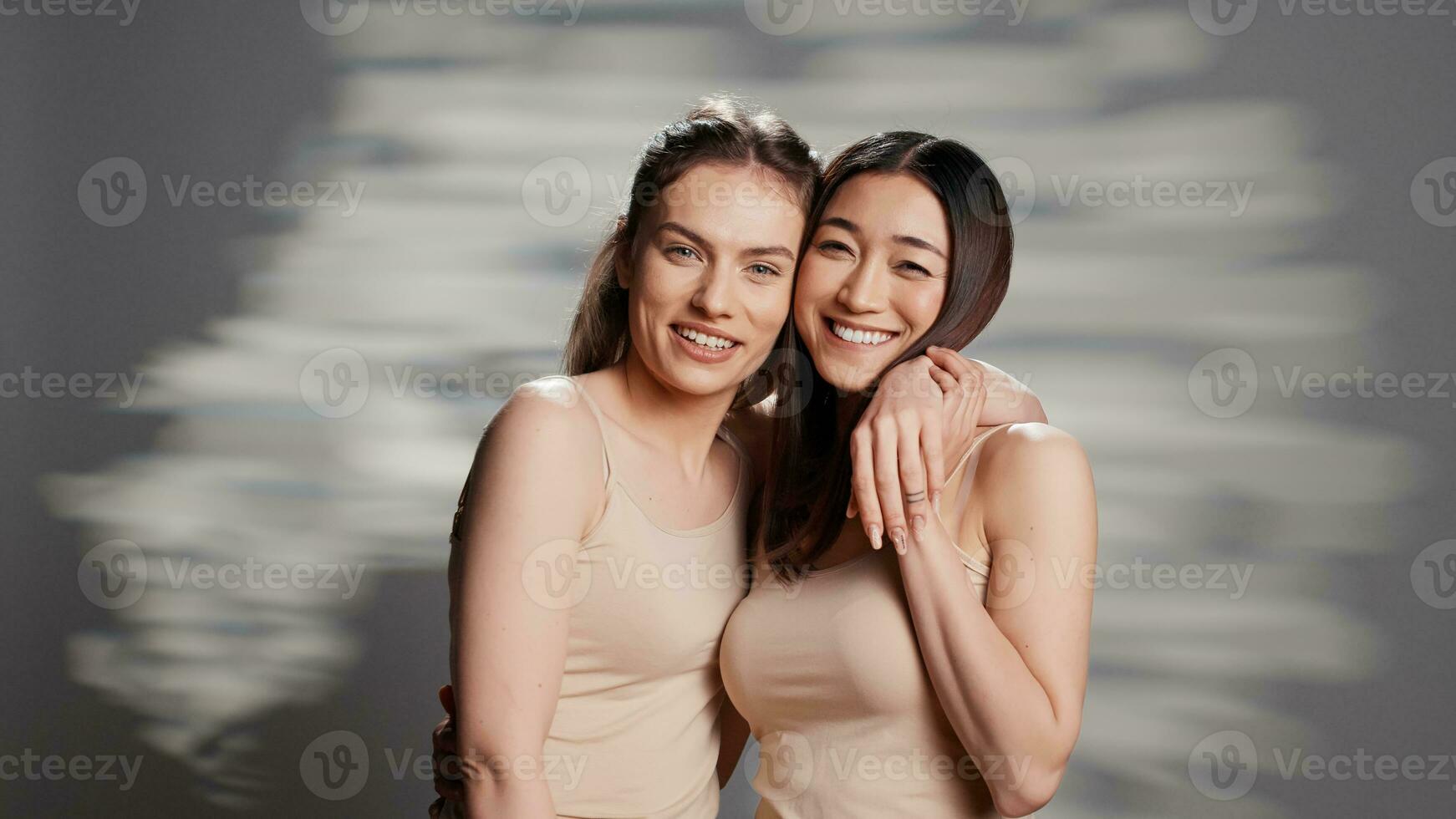 Diverse friends laughing and feeling positive on camera, posing for skincare ad campaign. Happy beautiful women promoting body acceptance and self confidence with beauty routine. photo