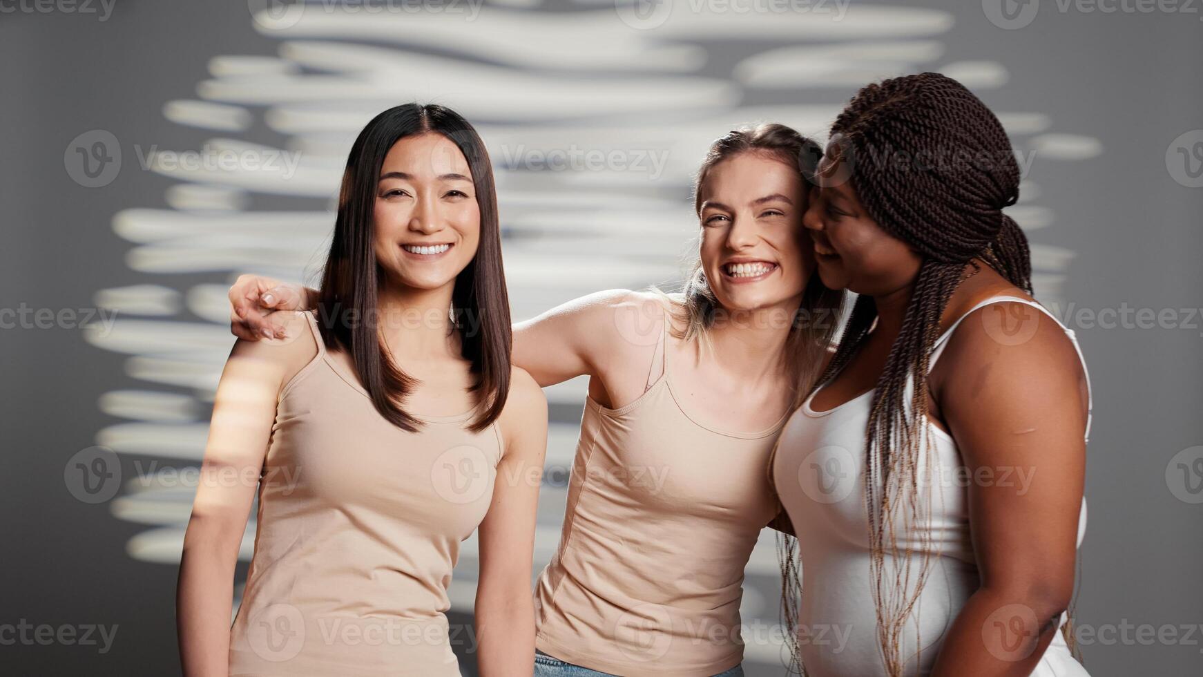 Interracial group of models promoting body positivity and feeling confident, laughing and having fun in studio. Women with different skintones and body types promoting body shapes and self confidence. photo