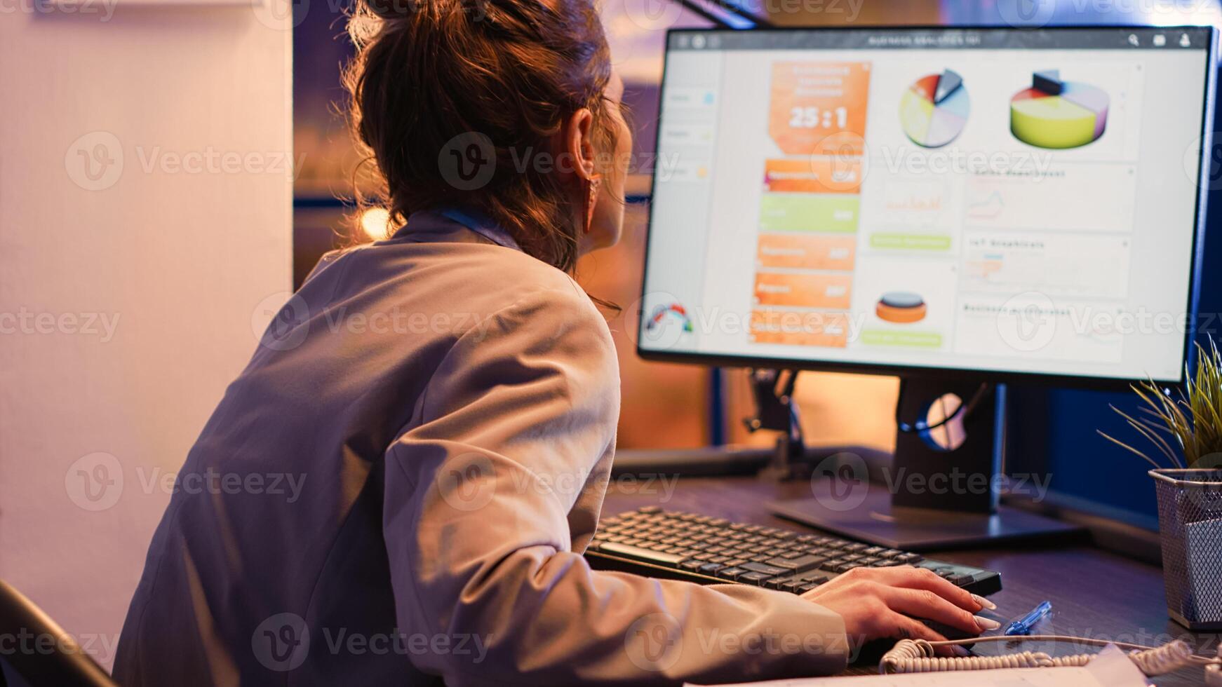 Investing agent working at night on financial project, analyzing business strategy and growth report on computer. Young employee checking research diagrams and planning company development. photo