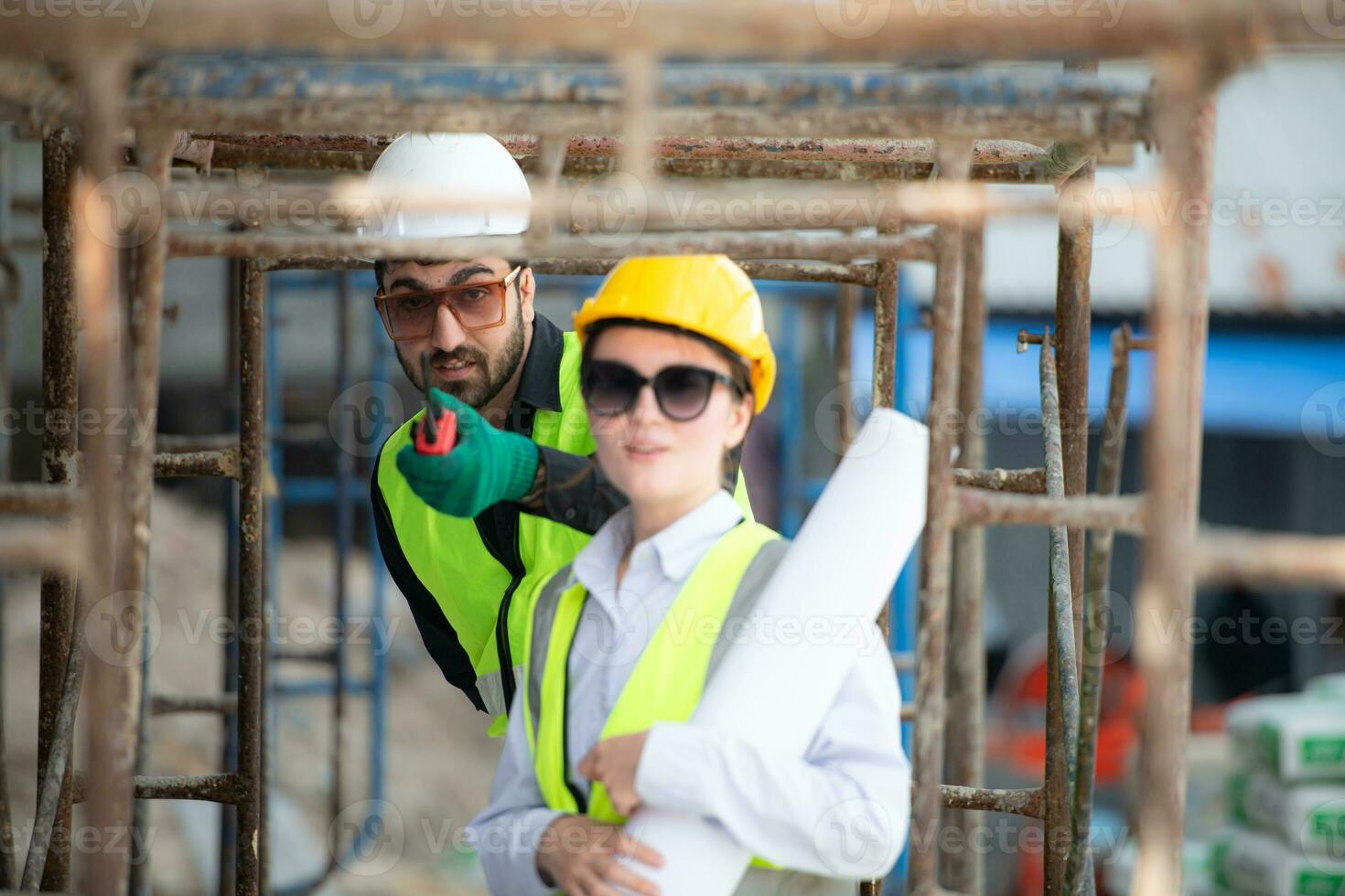 Engineer and architect working on the construction site, double-checking plans and process. photo