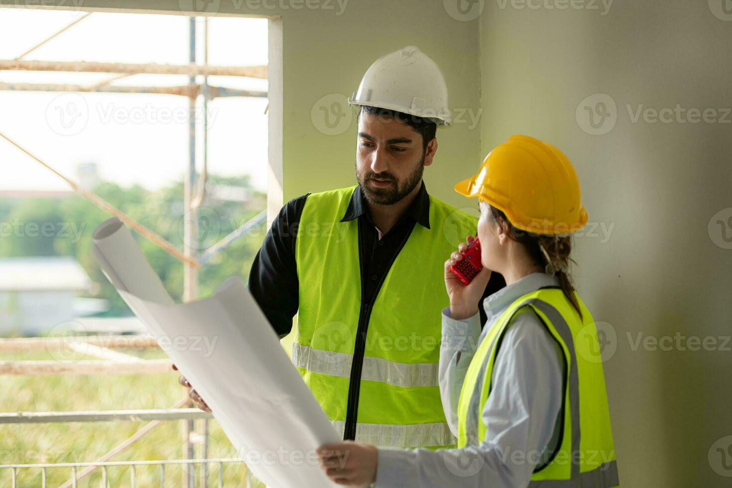 Engineer and architect working on the construction site, double-checking plans and process. photo