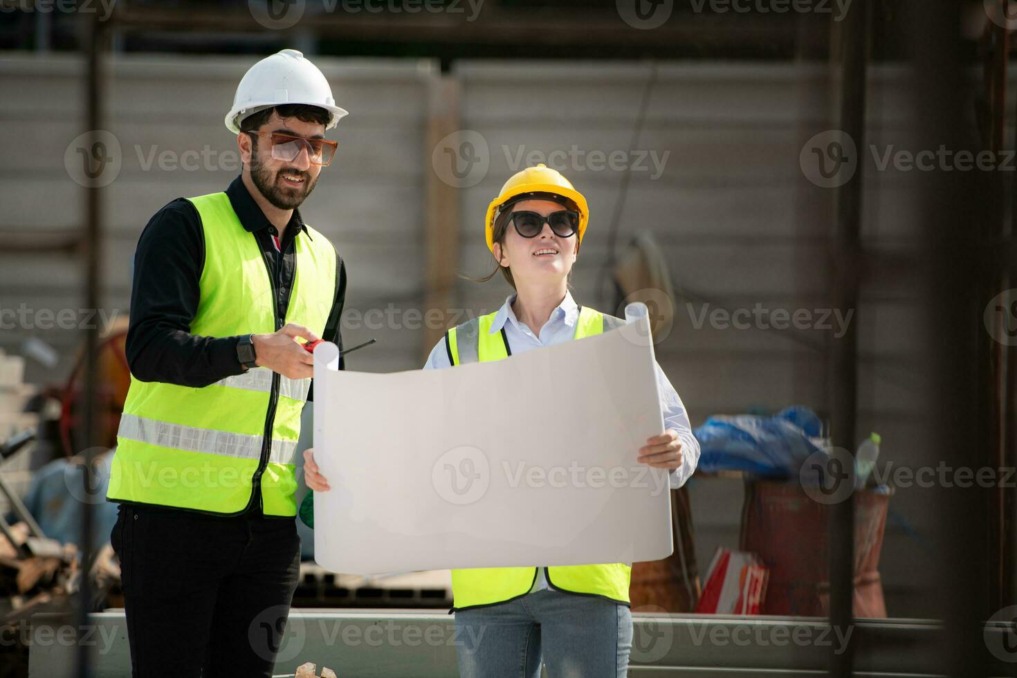 Engineer and architect working on the construction site, double-checking plans and process. photo