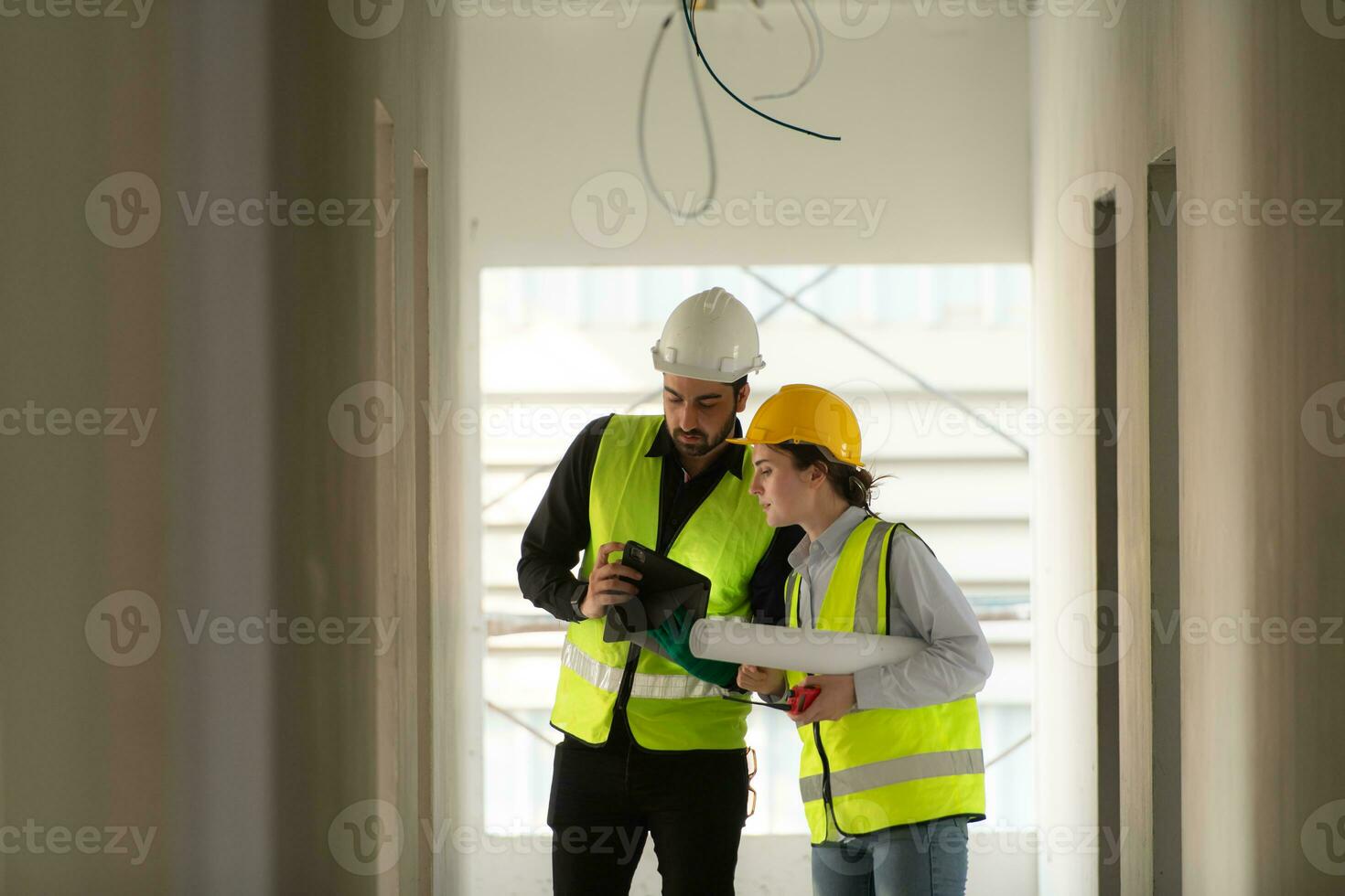 Engineer and architect working on the construction site, double-checking plans and process. photo